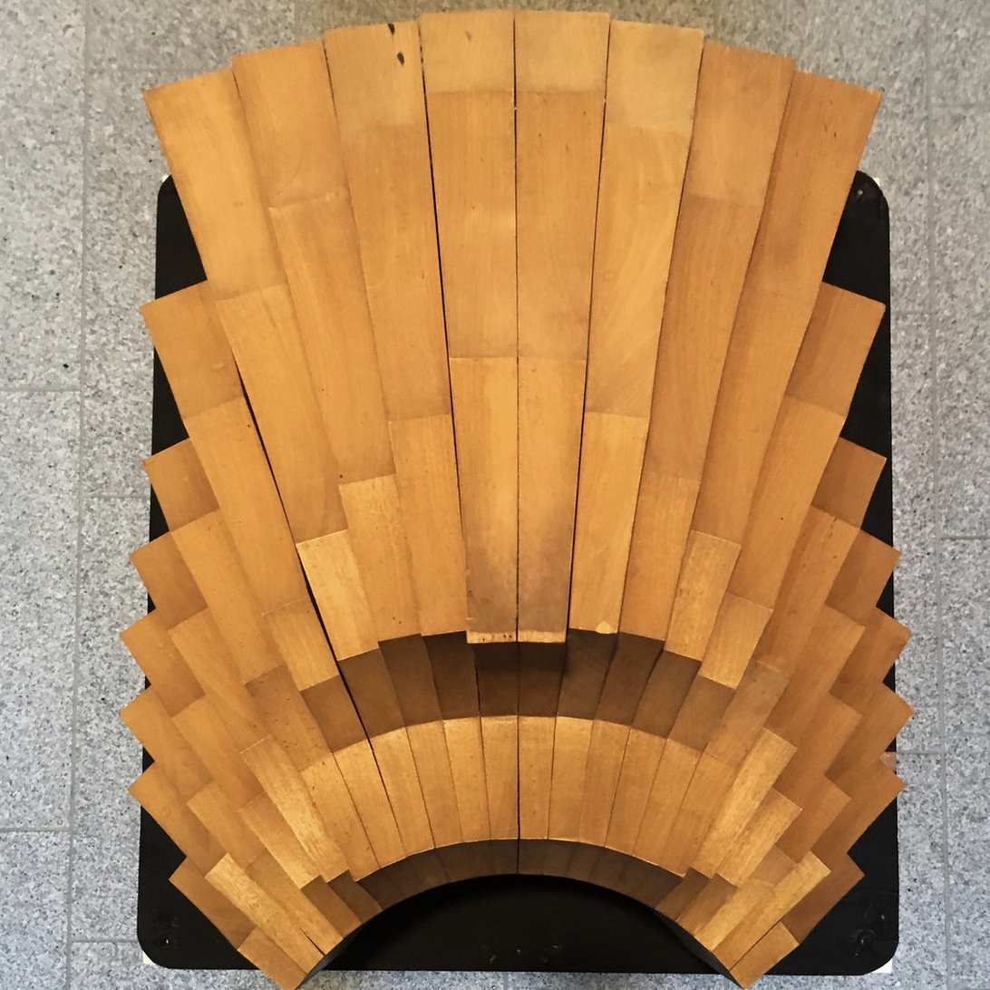 Ein modern eingerichtetes Wohnzimmer mit eleganten Akustikpaneelen aus Holz an der Wand hinter dem Sofa.